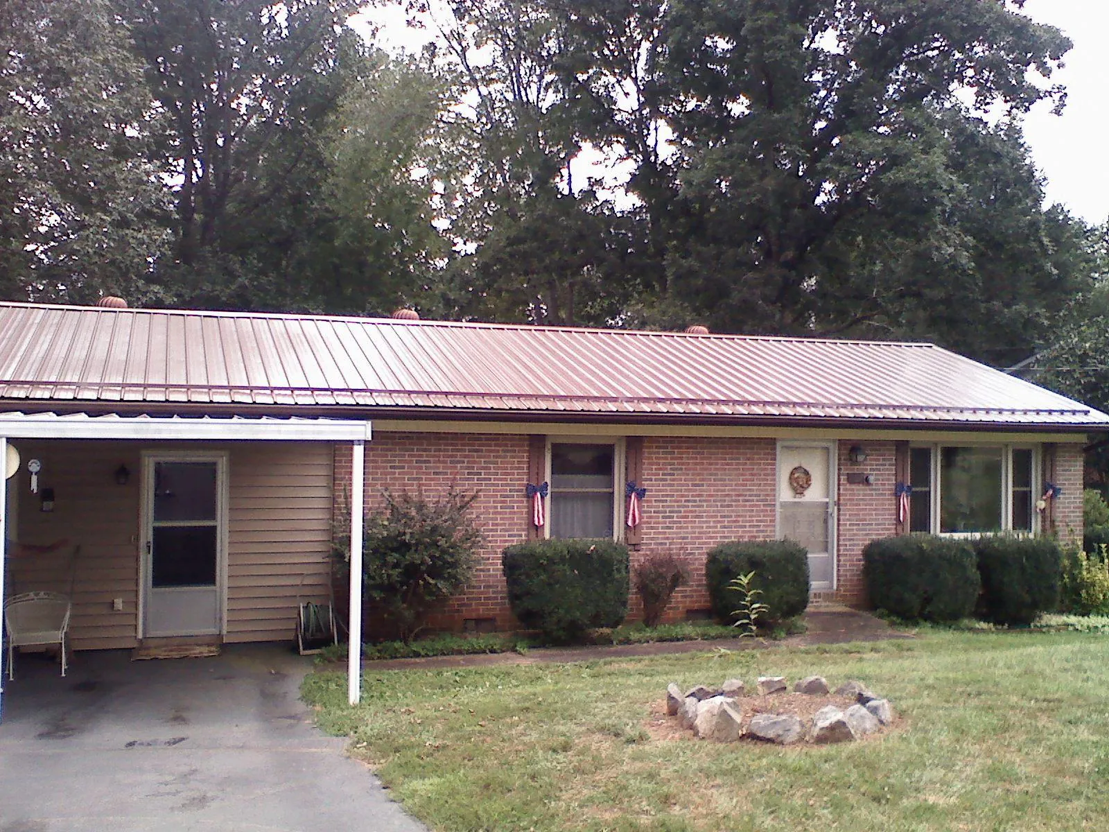Bronze metal roof and carport on a brick ranch home — Roof Repair work by our crew in Taylor