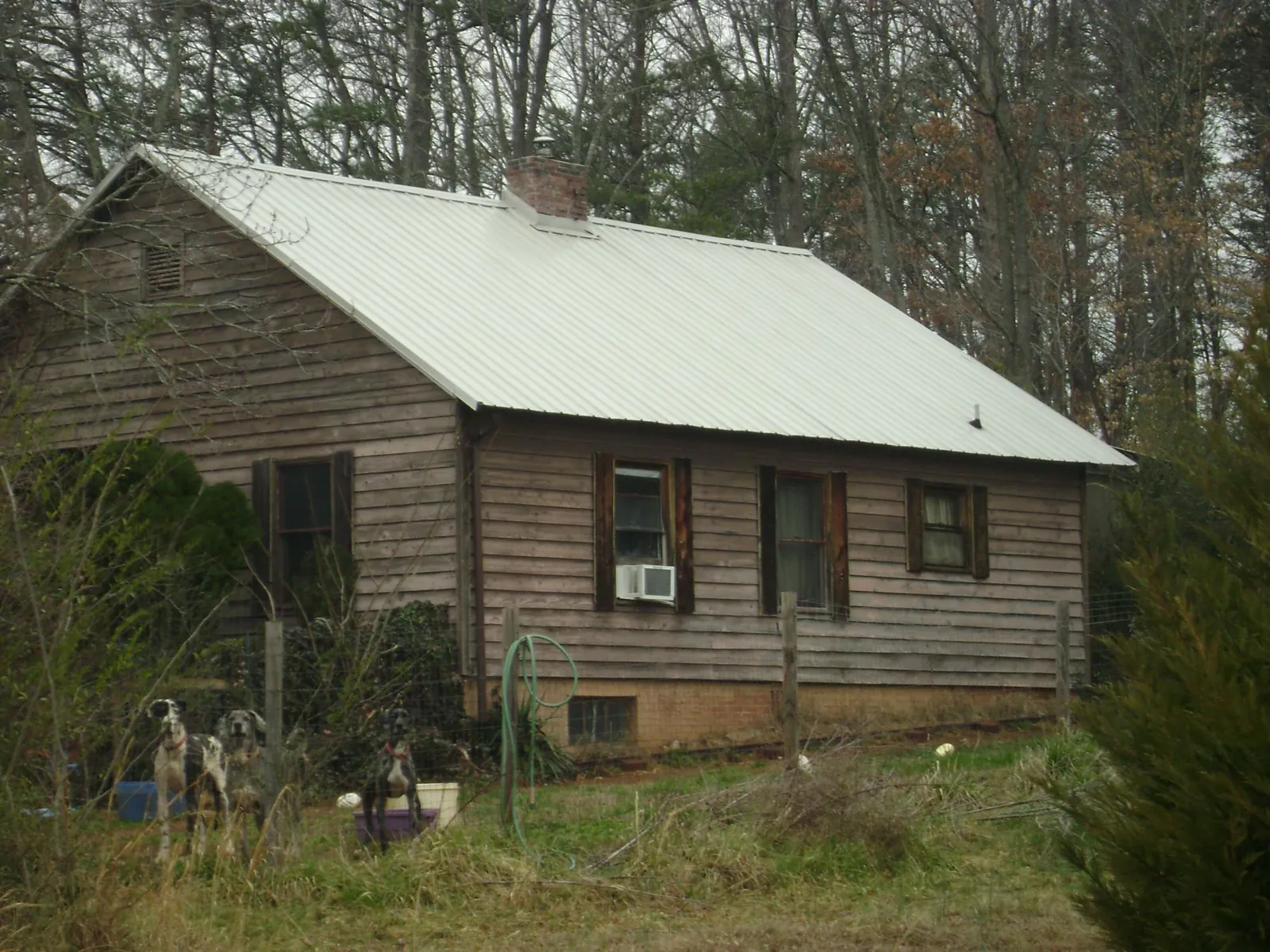 White metal roof on an old wood sided farmhouse, from a Metal Roof Installation job in Taylor